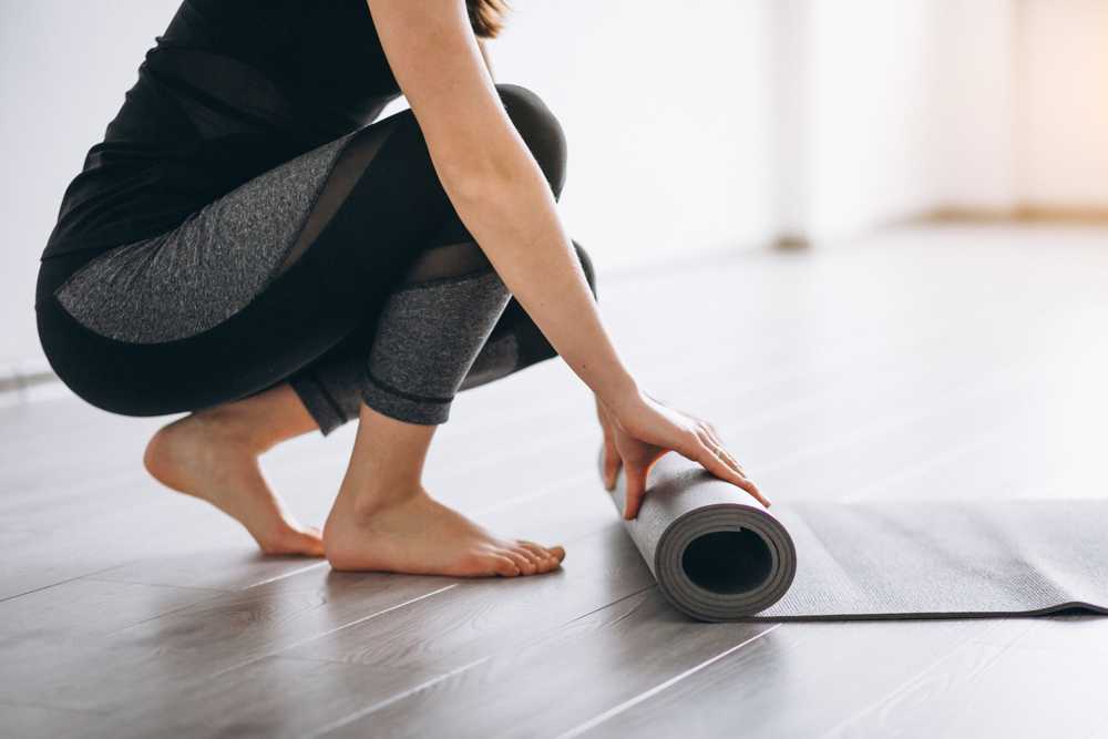 Woman rolling up yoga mat