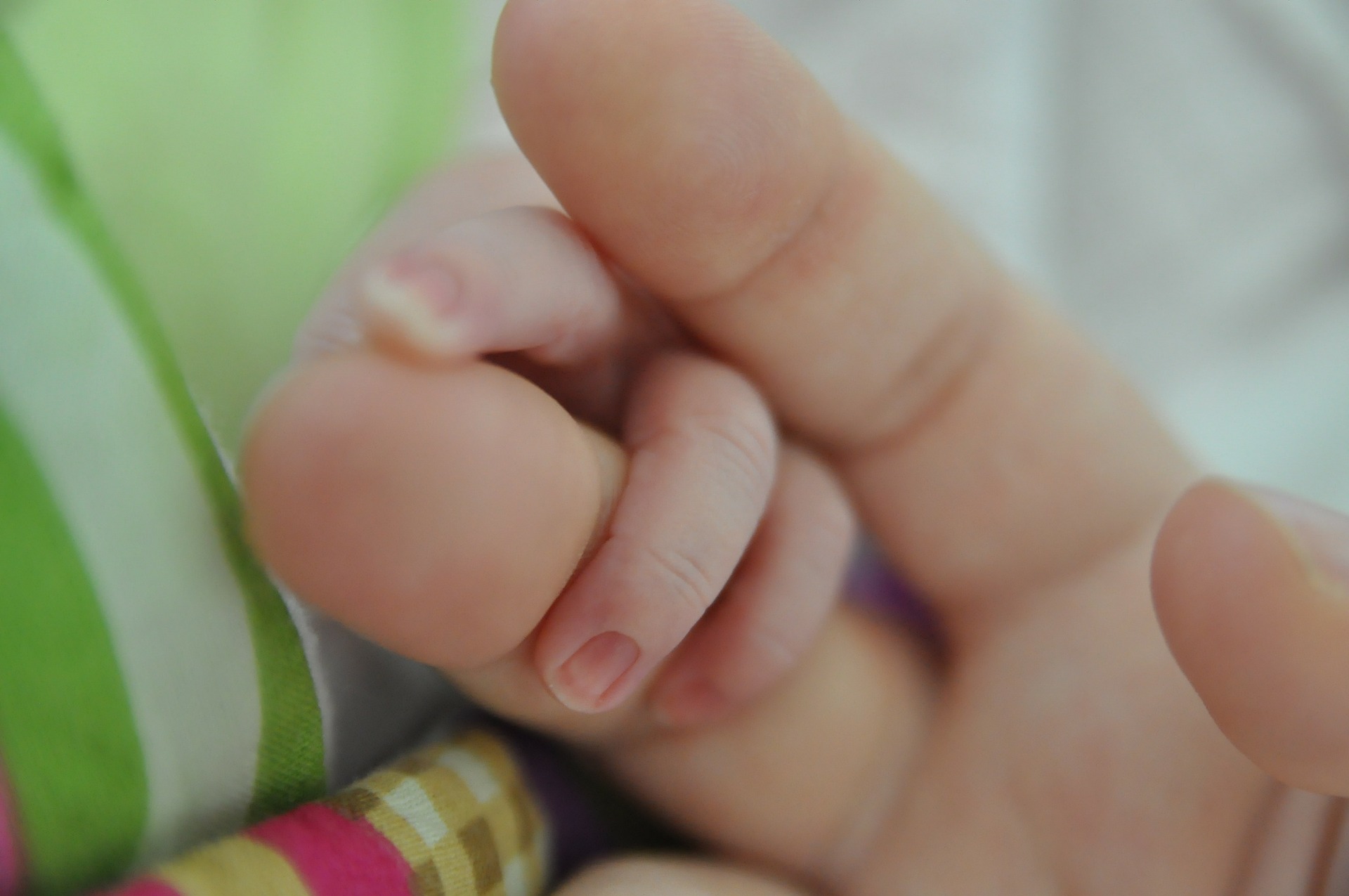 Infant holding mother's finger