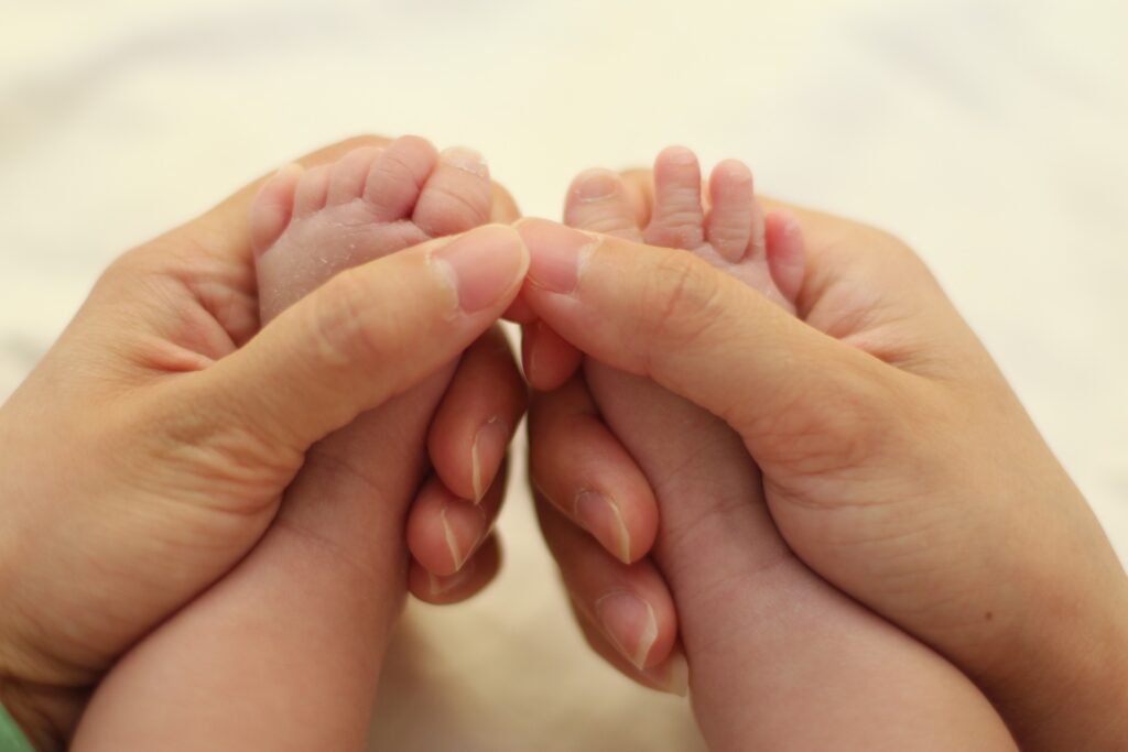 Adult holding infant's feet