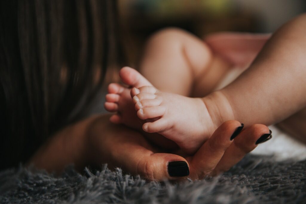 Mother holding baby's feet.