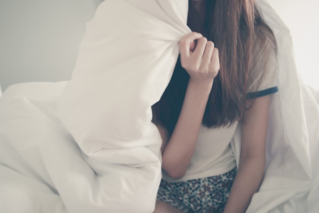 girl hiding behind pillow