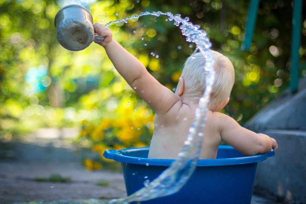 baby getting a bath in a bucket