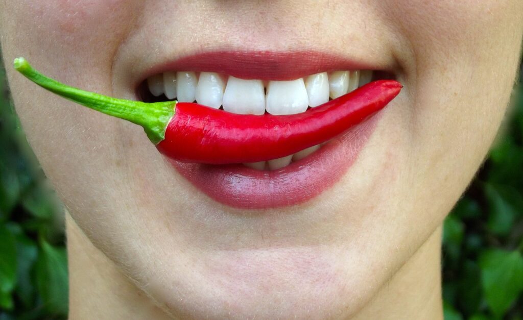 woman with hot pepper in her mouth